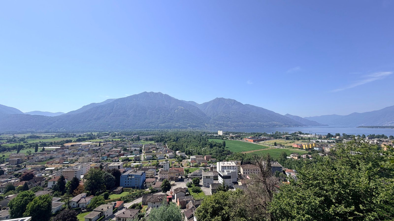 Panorama di Gordola, con il paese, il verde e il Lago Maggiore sullo sfondo